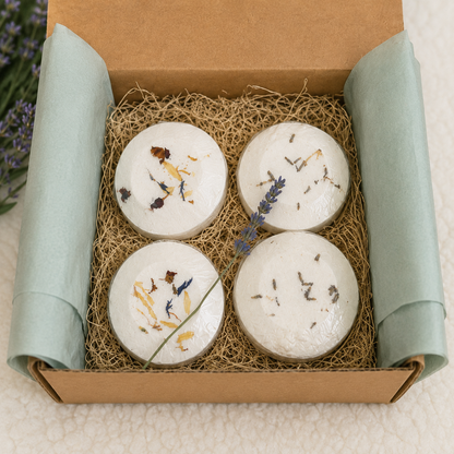 Open kraft gift box containing four handcrafted aromatherapy shower steamers nestled in natural excelsior with sage tissue paper and a lavender sprig.