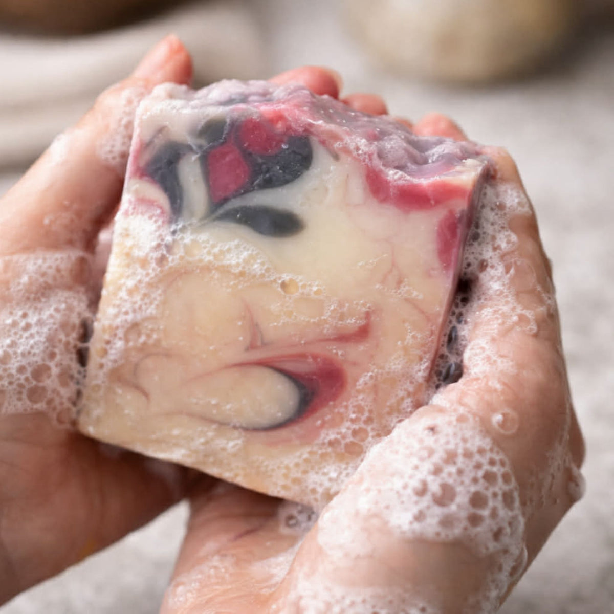 Close-up of Wildberry handmade soap showing its colorful marbled swirls and textured artisan finish.